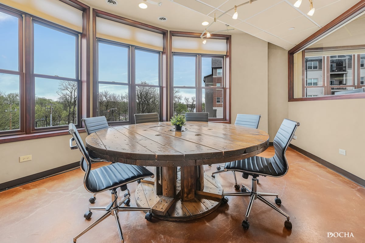 Suite 322 conference room with curved bay windows overlooking downtown Oswego park and the Fox River