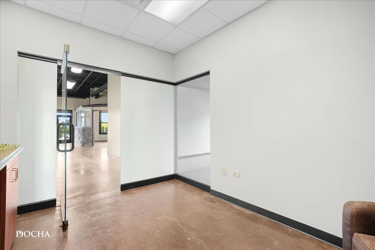 Suite 327 private entry with glass door and stained concrete floors at Washington Place, downtown Oswego, IL